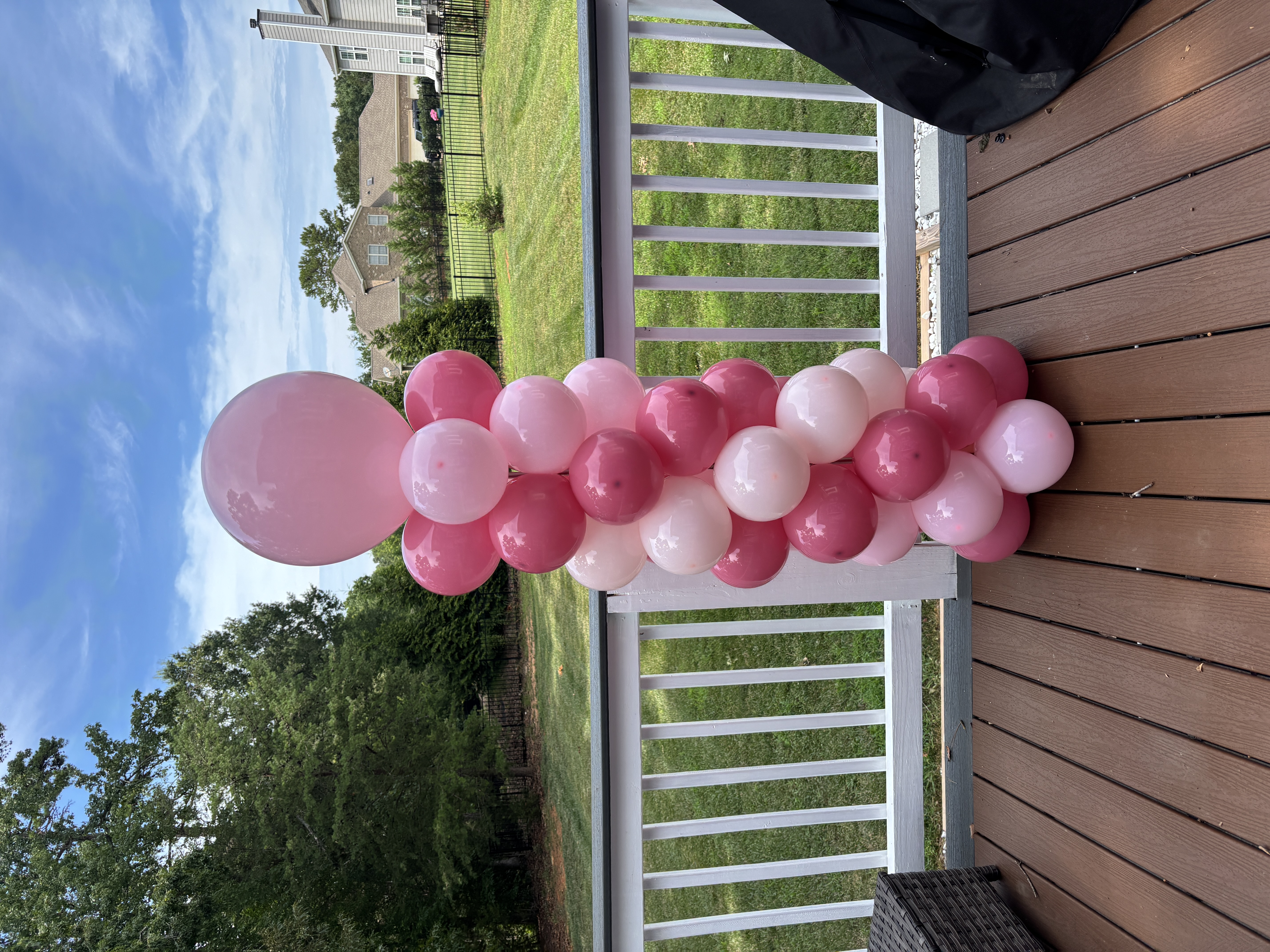 Pink balloon column on an outdoor deck