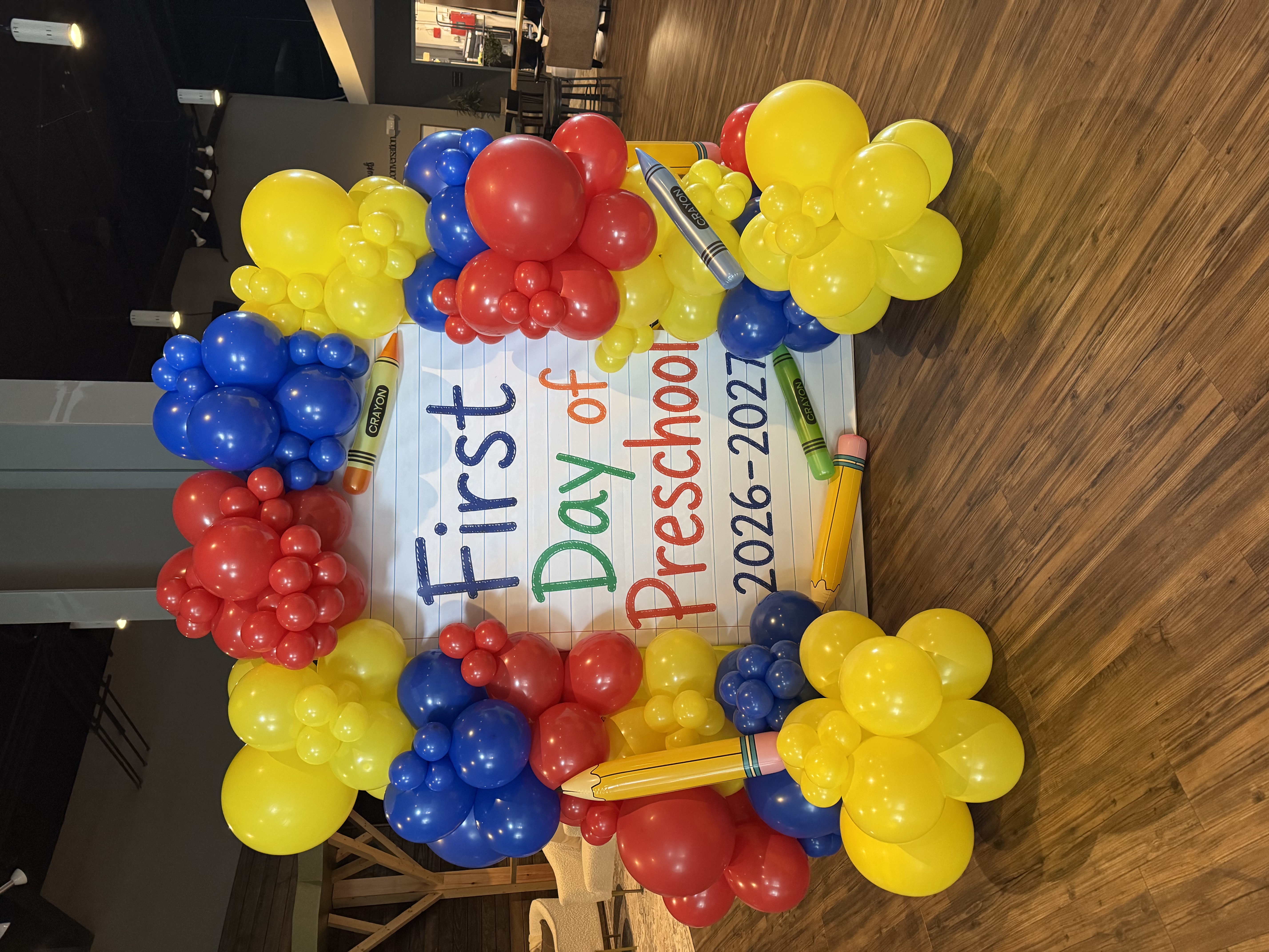 First day of preschool backdrop framed by red, blue, and yellow balloons
