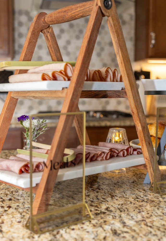 Tiered wooden stand with rolled deli meats