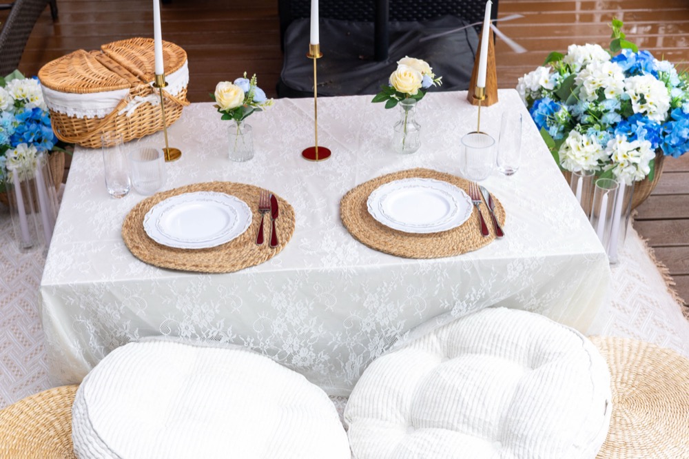 Sweetheart table with lace linen, candlesticks, and blue florals